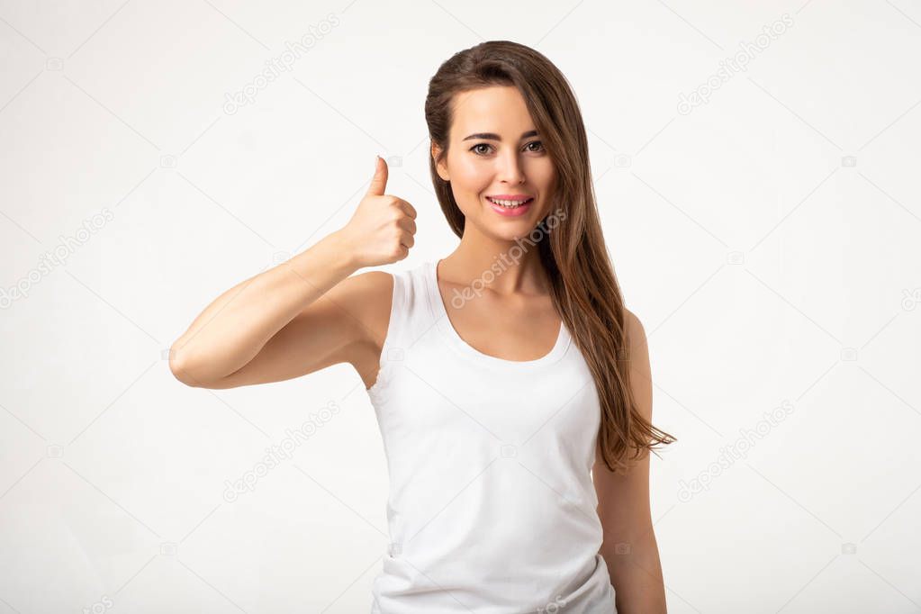 young brunette woman showing thumb up standing on white background