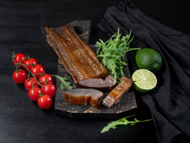 Deniz balık sebze ve roka koyu arka plan üzerinde füme