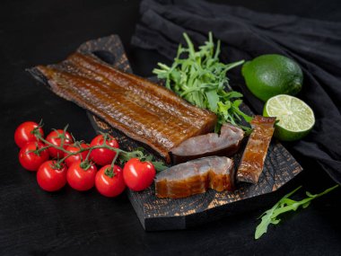 Deniz balık sebze ve roka koyu arka plan üzerinde füme