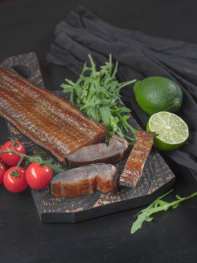 Deniz balık sebze ve roka koyu arka plan üzerinde füme