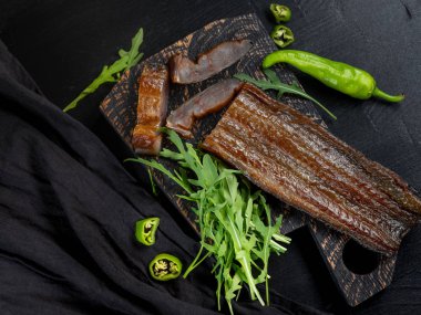 Yeşil biber ve koyu arka plan üzerinde roka ile deniz balık füme