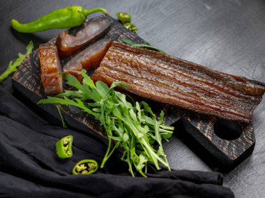 Yeşil biber ve koyu arka plan üzerinde roka ile deniz balık füme