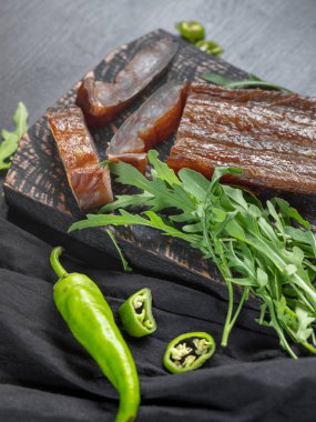 Yeşil biber ve koyu arka plan üzerinde roka ile deniz balık füme