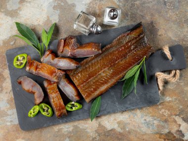 Yeşil biber ve defne üstünde tahta arka plan ile deniz balık füme