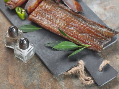 Yeşil biber ve defne üstünde tahta arka plan ile deniz balık füme