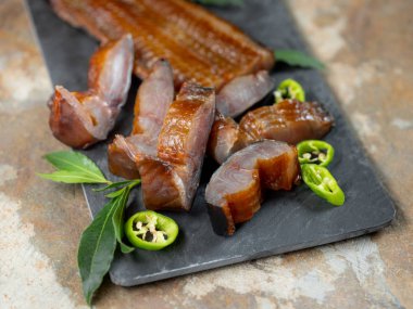 Yeşil biber ve defne üstünde tahta arka plan ile deniz balık füme