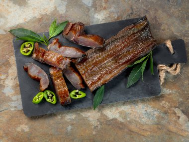 Yeşil biber ve defne üstünde tahta arka plan ile deniz balık füme