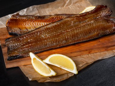 Koyu arka plan üzerinde limon ile deniz balık füme