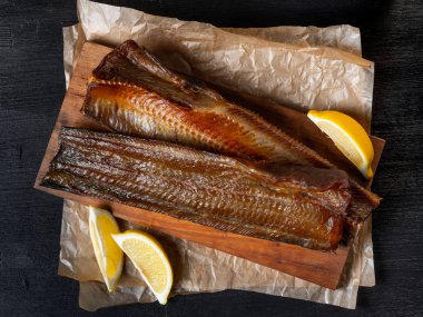 Koyu arka plan üzerinde limon ile deniz balık füme