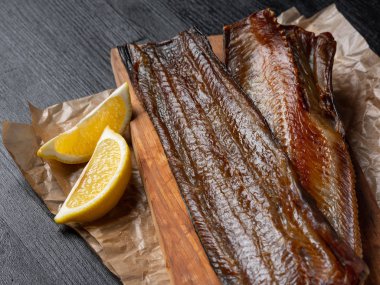 Koyu arka plan üzerinde limon ile deniz balık füme