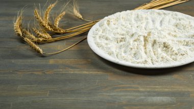 Ahşap masa üzerinde hamur için beyaz un ile plaka