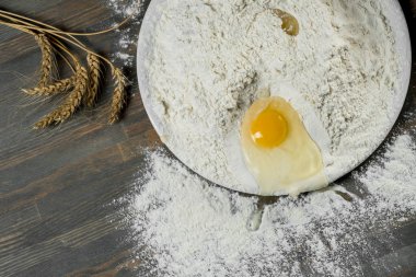 Ahşap masa üzerinde hamur için beyaz un ile plaka