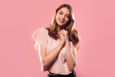 Uzun saçlı pembe arka plan izole gülümseyen çekici kadın portresi