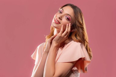 Uzun saçlı pembe arka plan izole gülümseyen çekici kadın portresi