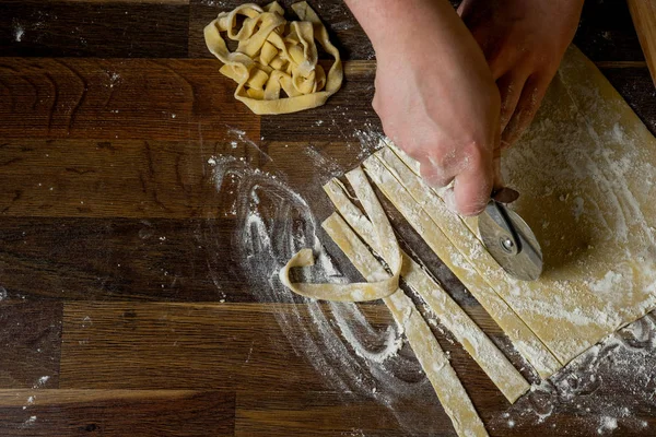 シェフ パスタ麺棒 紙袋とみじん切りパスタの小麦粉の木製テーブルの上の生地を切断 上面ビュー 家庭料理の概念 — ストック写真