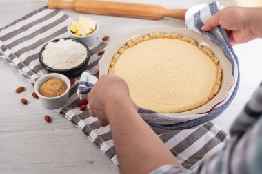 Chef malzemeler mutfak masasında yemeklerle tatlı cheesecake yemek