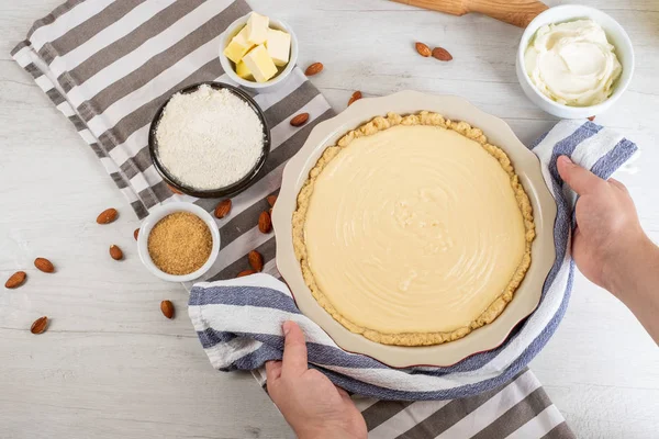 Chef cooking sweet cheesecake with cooking ingredients on kitchen table