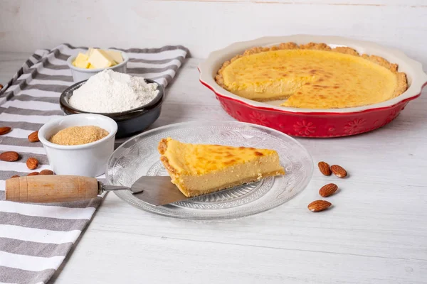 Baked sweet cheesecake with cooking ingredients on kitchen table