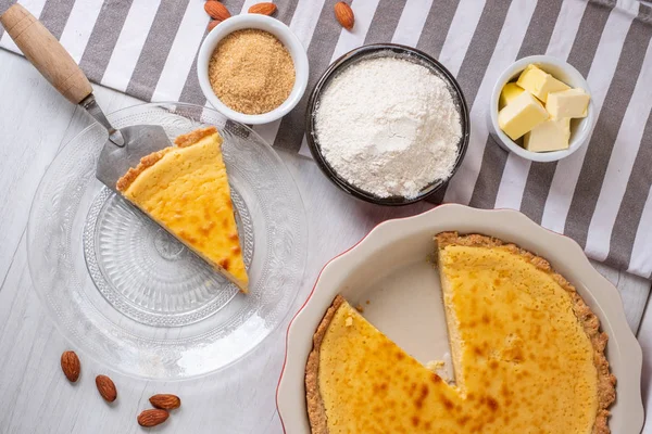 Baked sweet cheesecake with cooking ingredients on kitchen table