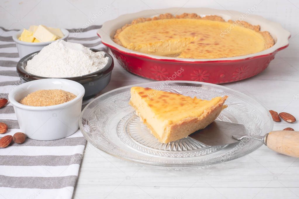Baked sweet cheesecake with cooking ingredients on kitchen table