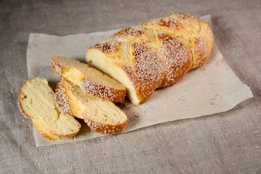 Keten kumaş üzerinde kağıt üzerinde taze dilimlenmiş challah Yahudi ekmek 