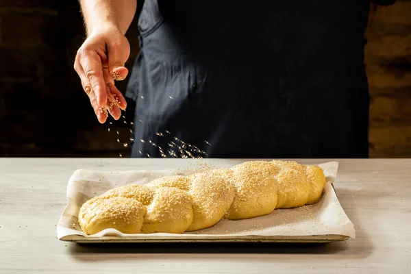 Male Baker Sprinkling Raw Challah Jewish Bread Sesame Seeds — Stock Photo, Image