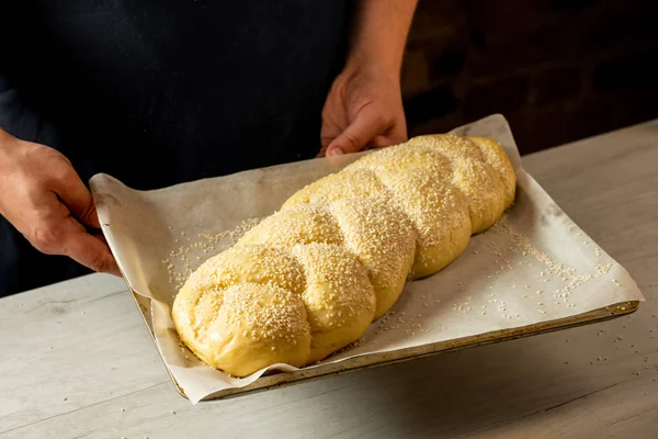 面包师手持烤盘与原始 Challah 传统犹太面包 — 图库照片