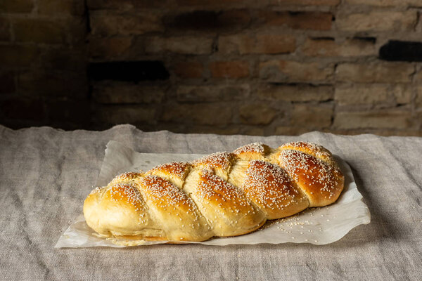 Fresh baked challah jewish bread sprinkled with sesame seeds on linen cloth 