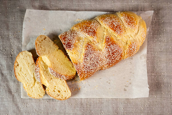 Fresh sliced challah jewish bread on paper over linen cloth 