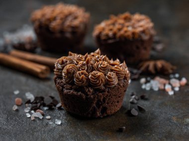 Karanlık taş zemin üzerine tuzlu karamel ile taze çikolata cupcakes görünümü Kapat