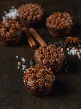 Karanlık taş zemin üzerine tuzlu karamel ile taze çikolata cupcakes görünümü Kapat