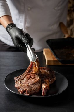 Izgara sığır eti plaka üzerinde hizmet veren adam görünümü Kapat 