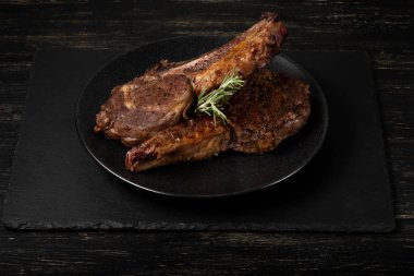 Ahşap arka plan üzerinde siyah plaka üzerinde Izgara Dana kaburga görünümü Kapat