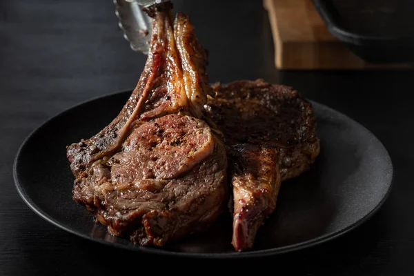 Taze pişmiş dana kaburga plaka üzerinde hizmet veren Şef görünümü Kapat
