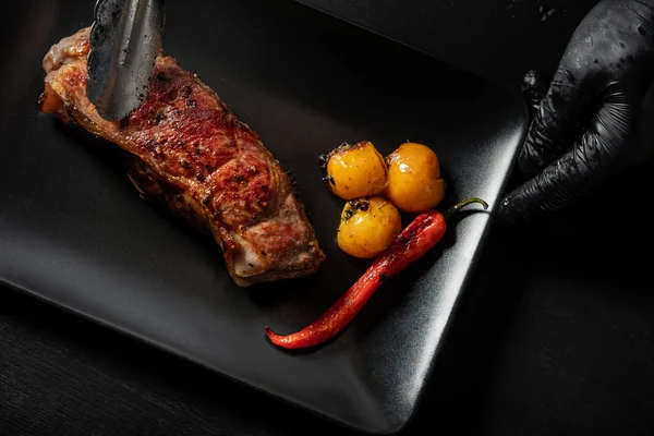 Izgara sığır eti plaka üzerinde hizmet veren adam görünümü Kapat 