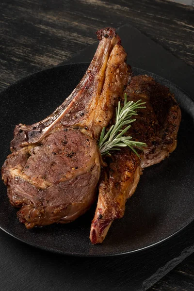 Ahşap arka plan üzerinde siyah plaka üzerinde Izgara Dana kaburga görünümü Kapat