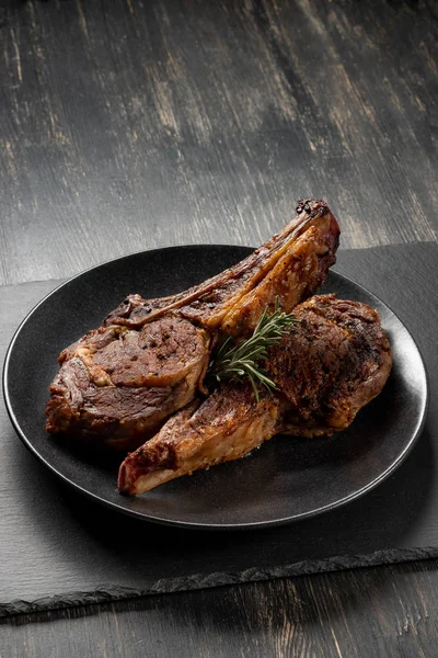 Ahşap arka plan üzerinde siyah plaka üzerinde Izgara Dana kaburga pişmiş taze