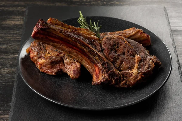 Ahşap arka plan üzerinde siyah plaka üzerinde Izgara Dana kaburga görünümü Kapat