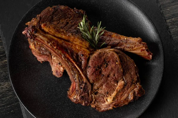 Ahşap arka plan üzerinde siyah plaka üzerinde Izgara Dana kaburga görünümü Kapat