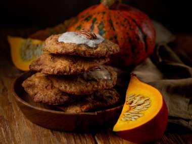 Ahşap arka plan üzerinde kabak ile ahşap plaka üzerinde taze kurabiye cevizli fındıklı görünümü Kapat