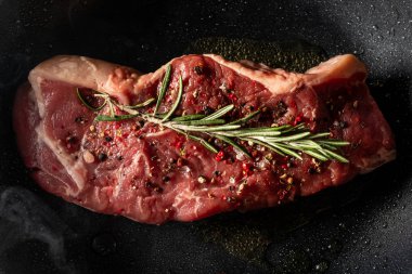 Taze biftek pişirme baharat ve biberiye ile görünümünü kapatmak Pan dal