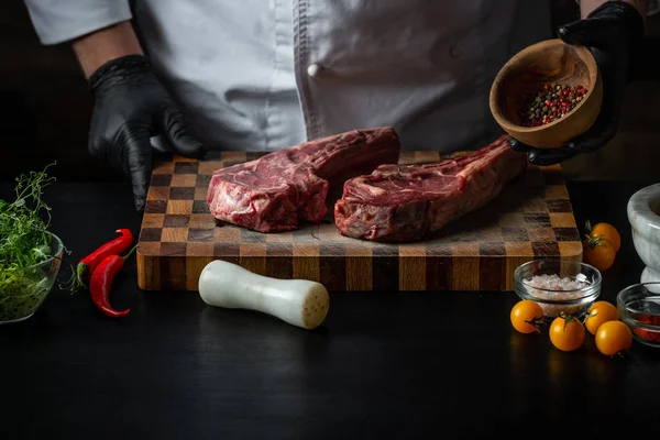 Erkek aşçı taze domuz kaburga tuz, biber ve baharat ahşap tahta üzerinde ile pişirme