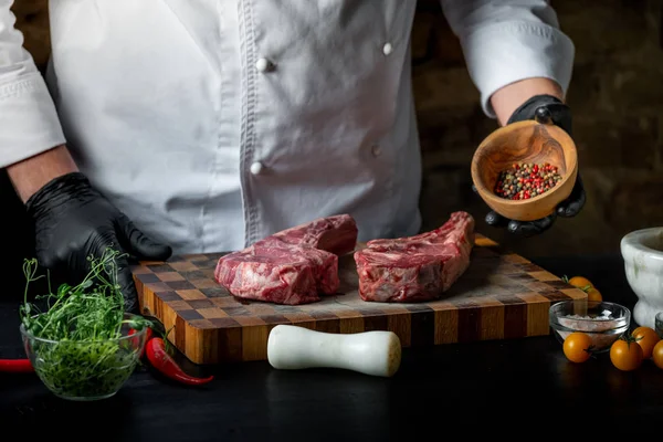 Erkek aşçı taze domuz kaburga tuz, biber ve baharat ahşap tahta üzerinde ile pişirme