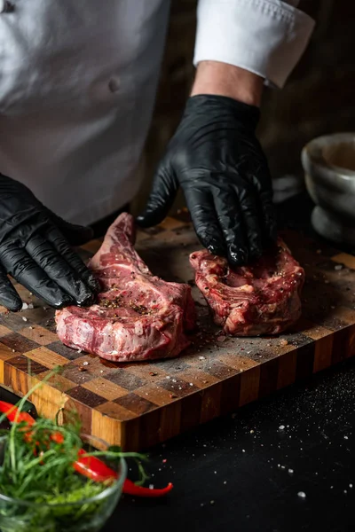 Tuz, biber ve baharat ahşap tahta üzerinde domuz kaburga pişirme adam