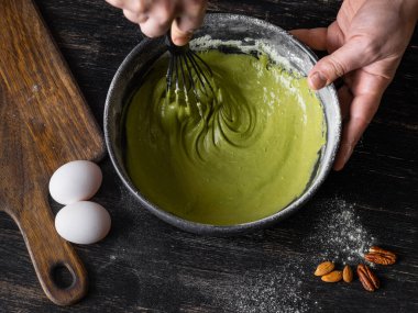 Adam ahşap yüzeyde matcha krep için hamur karıştırma görünümü Kapat