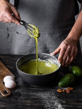 Adam ahşap yüzeyde matcha krep için hamur karıştırma görünümü Kapat