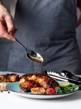 Adam dökme pişmiş tavuk budu üzerinde kireç, biber ve sarımsak sos