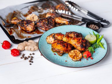 Taze pişmiş tavuk budu ile kireç dilim, otlar ve sarımsak mavi tabakta servis