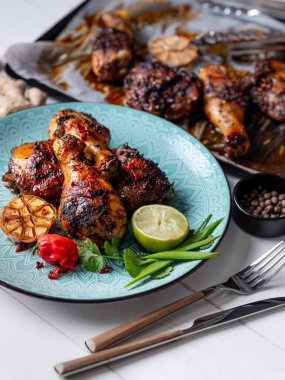 Taze pişmiş tavuk budu ile kireç dilim, otlar ve sarımsak mavi tabakta servis