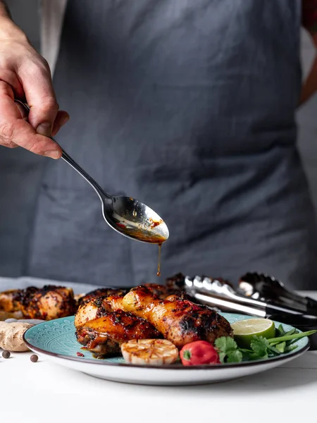 Man Pouring Sauce Baked Chicken Legs Served Lime Chili Pepper — Free Stock Photo